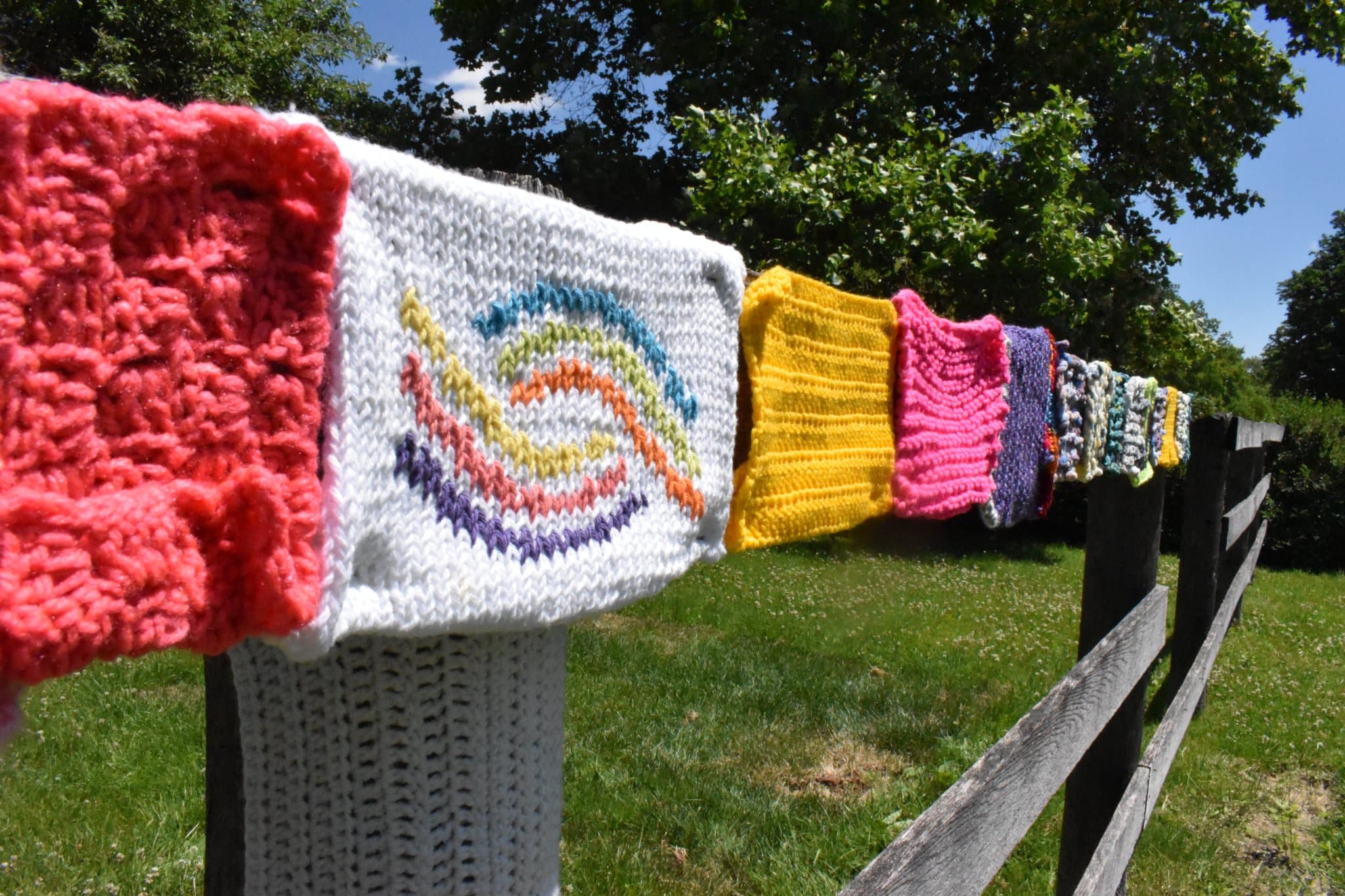knitted squares on wooden fence