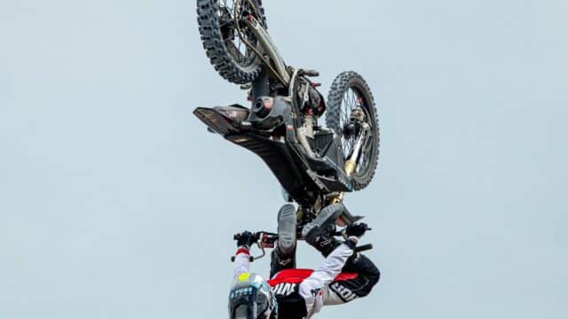 A person on a dirtbike is upside down in the air